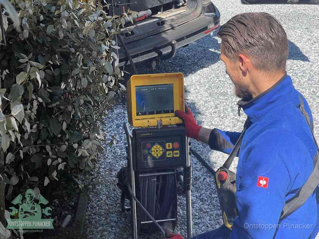 Een monteur bedient een rioolinspectiecamera met monitor en haspel om de verstopping in beeld te brengen in Pijnacker