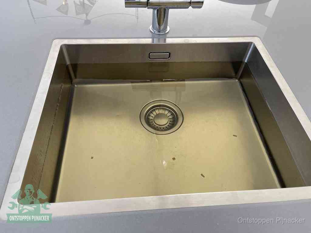 Een RVS spoelbak met stilstaand water dat niet wegloopt, een van de eerste signalen van een beginnende verstopping in Pijnacker