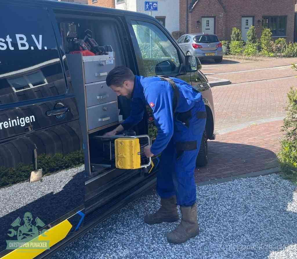Een monteur pakt gereedschap uit de bedrijfsbus, het moment om een professionele ontstoppingsdienst in te schakelen in Pijnacker